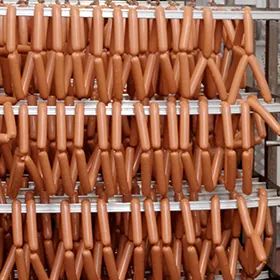 hangende worsten aan rookstokken in een rookkast
