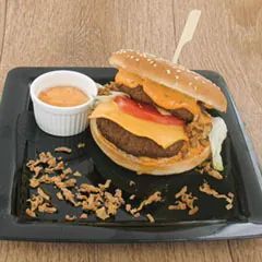Aantrekkelijke hamburger met de gecombineerde unieke smaak van zoete calypsosaus en gebakken uitjes.